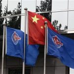 Flags of China National Offshore Oil Corp (CNOOC) fly beside the China flag in front of its headquarters building in Beijing July 25, 2012. REUTERS/Jason Lee