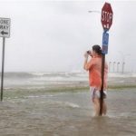 A resident photographs a flooded area outside of the levee system along the shore of Lake Pontchartrain as Hurricane Isaac approaches New Orleans, Louisiana, August 28, 2012. REUTERS/Jonathan Bachman