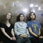 Members of the female punk band "Pussy Riot" (R-L) Nadezhda Tolokonnikova, Yekaterina Samutsevich and Maria Alyokhina sit in a glass-walled cage after a court hearing in Moscow, August 17, 2012. REUTERS/Maxim Shemetov