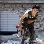A Free Syrian Army fighter runs for cover during heavy fighting in Salaheddine neighborhood of central Aleppo August 11, 2012. REUTERS/Goran Tomasevic