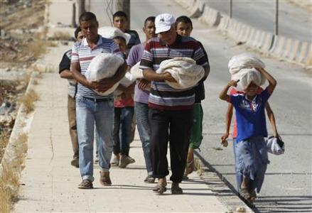 Civilians carry bread along a street in the city of Aleppo Civilians carry bread along a street in the city of Aleppo August 28, 2012. REUTERS/Youssef Boudlal