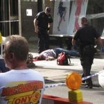 Bystanders and police look on as a man lies on the sidewalk after a shooting incident near the Empire State Building in New York August 24, 2012. REUTERS/Mickey C. Marrero