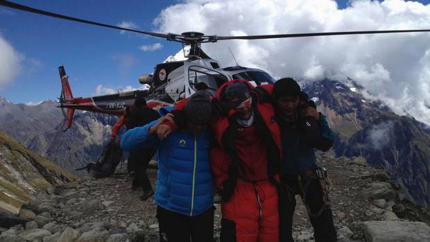 Rescue team members carry a tourist, centre, after an avalanche at Mount Manaslu Base Camp September 23, 2012.