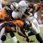 Oakland Raiders Marcel Reece (R) fights for a first down while being dragged down by Denver Broncos Joe Mays (L) and Rahim Moore (bottom) during their NFL football game in Denver, Colorado September 12, 2011. REUTERS/Mark Leffingwell