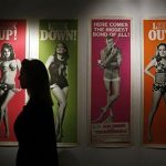 A worker walks past a complete set of original cinema door panel posters from the film "Thunderball", during a media preview of "50 Years of James Bond - the Auction", at Christie's in London September 28, 2012. The set is estimated to sell for 5,600 - 7,400 GBP ($9,100-12,000) at an online-only auction from September 28 to October 8. REUTERS/Stefan Wermuth