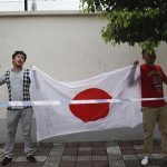 Demonstrators wave a Japanese national flag during an anti-Japan protest outside the Japanese consulate in Shanghai September 14, 2012. REUTER/Aly Song