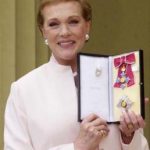 Dame Julie Andrews, star of Mary Poppins and the Sound of Music, shows off her award after receiving the honour of Dame Commander of the Order of the British Empire from the Queen at Buckingham Palace, May 16, 2000. REUTERS/POOL Old