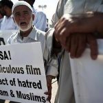 An Israeli Muslim protester holds a placard during a demonstration against a film produced in the U.S., which the protesters say insults Prophet Mohammad, outside the American embassy in Tel Aviv September 13, 2012. REUTERS/ Nir Elias