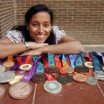 Spain's paralympic swimmer Teresa Perales poses with her 22 medals won during the four Paralympic Games she competed in at her home in Zaragoza, September 20, 2012. REUTERS/ Sergio Perez