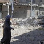 A woman walks on rubble as she crosses a street after checking her damaged house in in Aleppo's district of Bustan Al-Basha September 26, 2012. REUTERS/Zain Karam