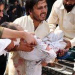 Pakistani men help an injured blast victim at a hospital following a suicide bomb attack in Peshawar on 13 Oct 2012.Photo: AFP
