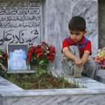 Five-year old Sahil Hazara sits on the grave of his brother Nadir Ali, who was killed by unidentified gunmen, at the Hazara graveyard in Mehrabad in Quetta August 31, 2012. REUTERS/Naseer Ahmed