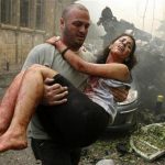 A wounded woman is carried at the site of an explosion in Ashrafieh, central Beirut, October 19, 2012. At least two people were killed and 15 wounded by a huge bomb that exploded in a street in central Beirut on Friday, witnesses and a security source said. REUTERS/Hasan Shaaban