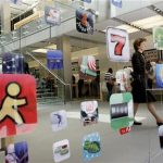 A woman walks past icons for Apple applications at the company's retail store in San Francisco, California in this April 22, 2009 file photo. REUTERS/Robert Galbraith/Files