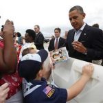 U.S. President Barack Obama signs a book about him for a boy scout upon his arrival in Richmond, Virginia May 5, 2012. REUTERS/Kevin Lamarque