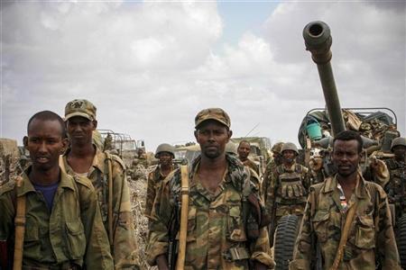 Somali National Army soldiers look on in Saa'moja, approximately 7km (4.3 miles) outside the Somali port city of Kismayu in this October 1, 2012 handout photograph released by the African Union-United Nations Information Support Team. Somalia's al Shabaab rebels retreated from the southern port of Kismayu overnight, abandoning the last major bastion of their five-year revolt to an offensive by African Union and Somali government troops. REUTERS/African Union-United Nations Information Support Team/Stuart Price/Handout