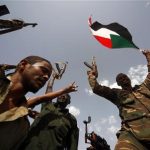 Sudanese military soldiers hold up their weapons and wave the Sudanese flag during the visit of Sudanese President Omar al-Bashir (not seen) in Heglig April 23, 2012. REUTERS/Mohamed Nureldin Abdallah