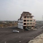 A house is seen in the middle of a newly built road in Wenling, Zhejiang province, November 24, 2012. An elderly couple refused to sign an agreement to allow their house to be demolished. They say that compensation offered is not enough to cover rebuilding costs, according to local media. Their house is the only building left standing on a road which is paved through their village. REUTERS/Aly Song (CHINA - Tags: BUSINESS CONSTRUCTION POLITICS SOCIETY)