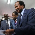 Cameroon's President Paul Biya holds a ballot paper before casting his vote at a polling centre in the capital Yaounde October 9, 2011. REUTERS/Akintunde Akinleye