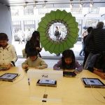 Young holiday shoppers interact with the iPad at the Apple Store during Black Friday in San Francisco, California, November 23, 2012. REUTERS/Stephen Lam