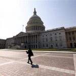 A woman walks past the U.S. Capitol in Washington September 25, 2012. REUTERS/Kevin Lamarque