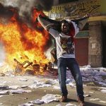 A protester cheers as items ransacked from an office of the Muslim Brotherhood's Freedom and Justice Party burn in Alexandria November 23, 2012. REUTERS/Stringer