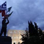 A protestor raises flags of Portugal, Italy, Greece and Spain in front of the parliament in Syntagma square during a 48-hour strike by the two major Greek workers unions in central Athens November 7, 2012. REUTERS/John Kolesidis