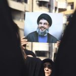 A Lebanese Hezbollah supporter carries a picture of Hezbollah leader Sayyed Hassan Nasrallah as she takes part in a ceremony marking Ashura in Beirut's suburbs, November 25, 2012. Hezbollah leader Sayyed Hassan Nasrallah warned Israel on Sunday that thousands of rockets would rain down on Tel Aviv and other Israeli cities if Israel attacked Lebanon. REUTERS/Khalil Hassan