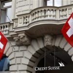 Switzerland national flags fly beside the logo of Swiss bank Credit Suisse (CS) at the company's headquarters in Zurich April 13, 2012. REUTERS/Arnd Wiegmann