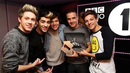 Members of boy band One Direction pose at the BBC's Radio One studio to mark their topping the British singles and album charts on Sunday November 18, 2012, in this handout publicity photo. Credit: Reuters/Handout