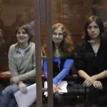 Members of the female punk band "Pussy Riot" (L-R) Yekaterina Samutsevich, Maria Alyokhina and Nadezhda Tolokonnikova sit in a glass-walled cage before a court hearing in Moscow October 10, 2012. REUTERS/Maxim Shemetov