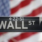 A sign for Wall Street is seen with a giant American flag in the background across from the New York Stock Exchange November 5, 2012. REUTERS/Chip East
