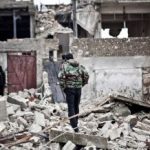 Free-Syrian-Army-fighters-walk-amid-the-ruins-of-a-village-situated-a-short-distance-from-an-area-where-fighting-between-rebels-and-government-forces-continues