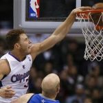 Los Angeles Clippers Blake Griffin (L) slam dunks over Dallas Mavericks Chris Kaman during their NBA basketball game in Los Angeles, California, December 5, 2012. REUTERS/Lucy Nicholson