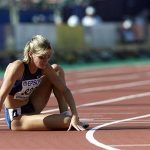 Suzy Favor-Hamilton of the U.S. sits on the track after a DNF in her heat of the 1500 meter semifinal at the World Championships in Athletics, in Edmonton August 5, 2001. REUTERS/Gary Hershorn