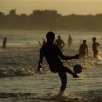 A man kicks a ball at the Copacabana beach in Rio de Janeiro December 25, 2012. REUTERS/Pilar Olivares