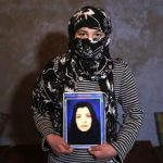 Fatima, 13, holds a picture of her mother Narges Rezaeimomenabad, suspected of killing a U.S. contractor at a police headquarters, at her home in Kabul December 26, 2012. REUTERS/Mohammad Ismail