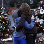 A woman embraces a boy next to a makeshift memorial for victims who died in the December 14 shootings at Sandy Hook Elementary School, in Newtown, Connecticut December 18, 2012. REUTERS/Shannon Stapleton
