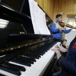 In this Monday, Jan. 7, 2013, photo an Afghan girl, right, practices playing the piano in a class at the Afghanistan National Institute of Music in Kabul, Afghanistan. Dozens of Afghan teenagers including former street kids or orphans aged 10 to 22, will be playing in the Afghan Youth Orchestra which begins a 12-day U.S. tour on Feb. 3 and includes concerts at Washington's Kennedy Center - President Barrack Obama has been invited - New York's Carnegie Hall and the New England Conservatory in Boston. (AP Photo/Musadeq Sadeq)