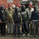 Indian-policemen-stand-with-six-men-face-covered-in-black-sheet-suspected-in-a-gang-rape-of-a-bus-passenger-in-Punjab-state-India-January-13-2013.