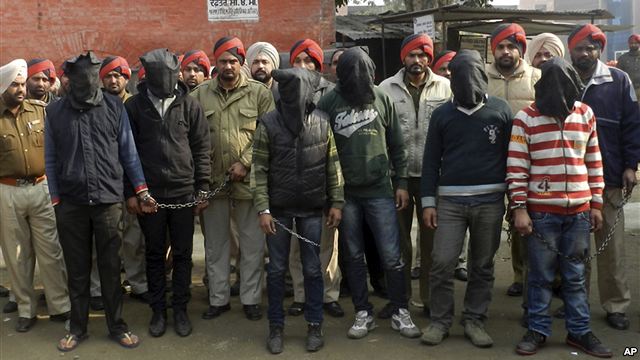 Indian-policemen-stand-with-six-men-face-covered-in-black-sheet-suspected-in-a-gang-rape-of-a-bus-passenger-in-Punjab-state-India-January-13-2013.