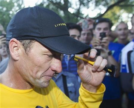 Lance Armstrong walks back to his car after running at Mount Royal park with fans in Montreal August 29, 2012. REUTERS/Christinne Muschi