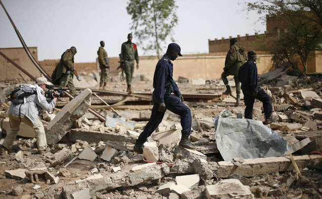 Malian soldiers stroll through the rubble of a former army base in Konna, 430 miles north of the capital, Bamako, leveled in fighting with Islamist rebels.