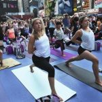 People practice yoga on the morning of the summer solstice in New York's Times Square June 20, 2012. REUTERS/Shannon Stapleton