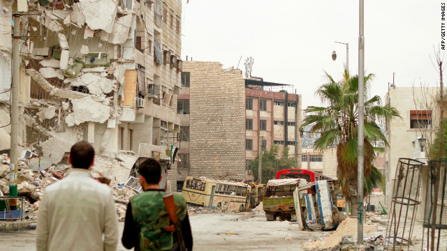 Rebel fighters inspect the debris in the Bustan al-Basha district in Aleppo on January 1, 2013