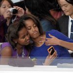 Sasha (L) and Malia Obama, daughters of US President Barack Obama, take a photo of themselves during the Presidential Inaugural Parade on January 21, 2013 in Washington, DC. AFP PHOTO/JOE KLAMARJOE KLAMAR/AFP/Getty Images ** TCN OUT **