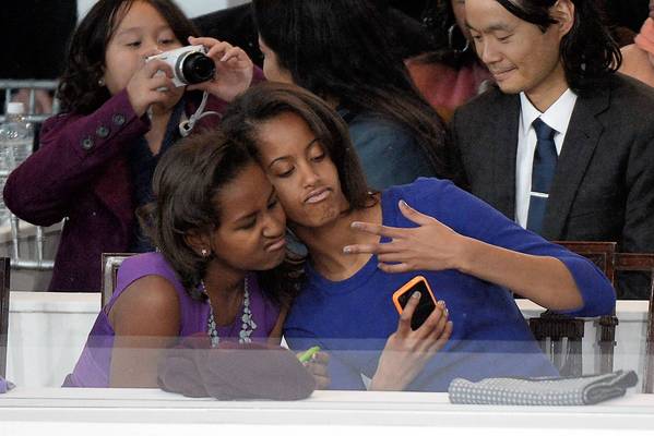 Sasha (L) and Malia Obama, daughters of US President Barack Obama, take a photo of themselves during the Presidential Inaugural Parade on January 21, 2013 in Washington, DC.   AFP PHOTO/JOE KLAMARJOE KLAMAR/AFP/Getty Images ** TCN OUT **