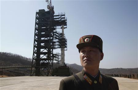 A soldier stands guard in front of a rocket sitting on a launch pad at the West Sea Satellite Launch Site, during a guided media tour by North Korean authorities in the northwest of Pyongyang in this April 8, 2012 file photo. REUTERS/Bobby Yip/Files