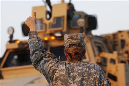 U.S. Army convoys are given a thumb up from a female soldier after crossing into Kuwait during the last convoy out of Iraq in this December 18, 2011 file photograph. REUTERS/Shannon Stapleton/Files