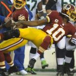 Washington Redskins quarterback Robert Griffin III flies through the air as he is knocked out of bounds during the first half of an NFL wild card playoff football game against the Washington Redskins in Landover, Md., Sunday, Jan. 6, 2013. (AP Photo/Richard Lipski)
